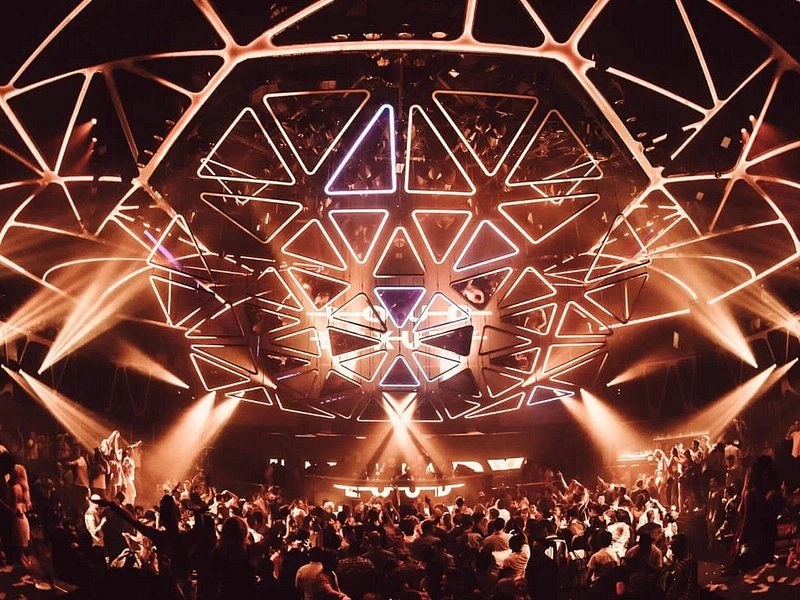 A geometric light rig firing over a packed nightclub floor in Las Vegas